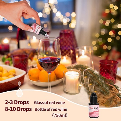 Table set up for a Christmas feast with someon putting wine drops in red wine to remove preservatives